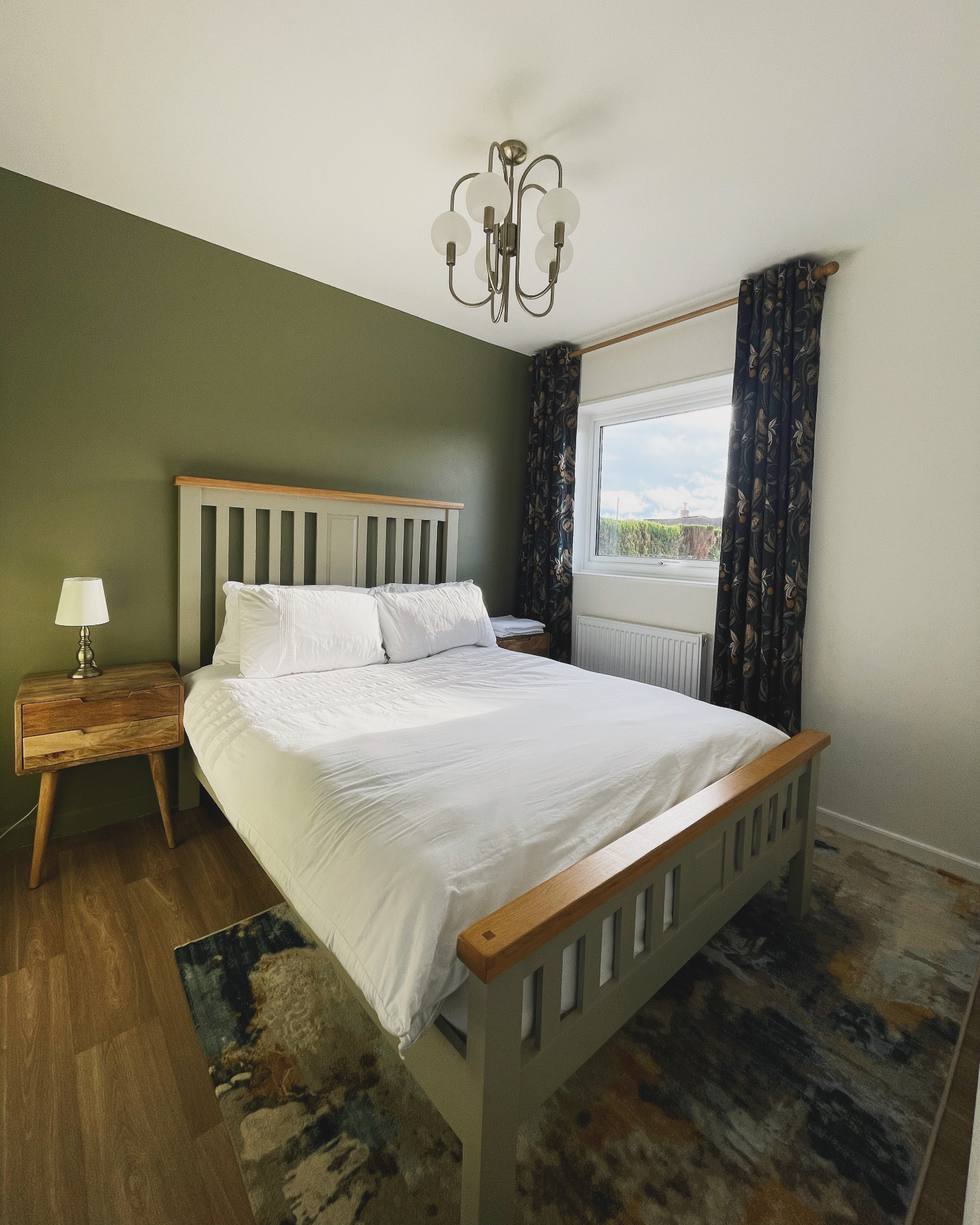 The bedroom with an olive-green wall at Ty Ray Penmaes